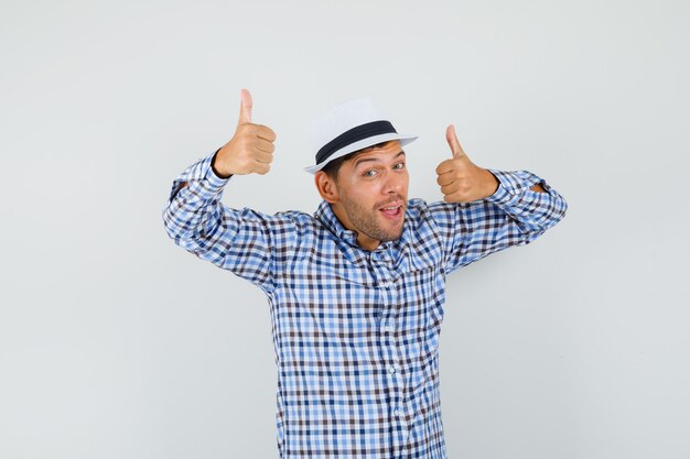 Young male showing double thumbs up in checked shirt