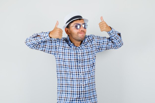 Young male showing double thumbs up in checked shirt