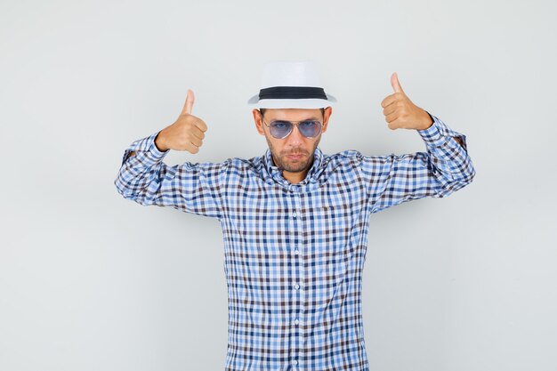 Young male showing double thumbs up in checked shirt