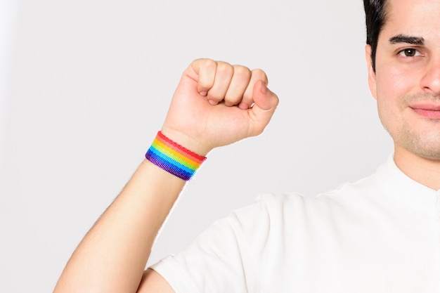 Young male showing his fist with LGBT pride bracelet