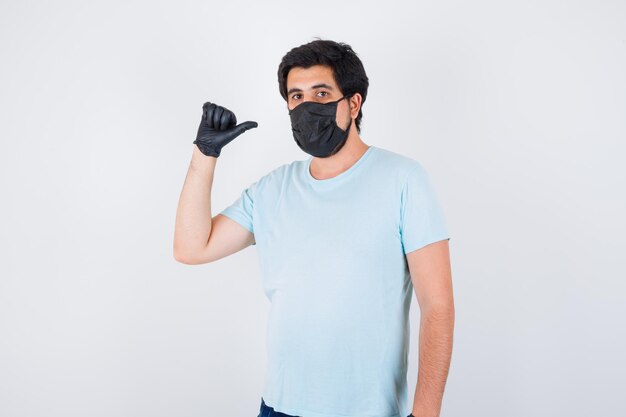 Young male showing middle thumb in t-shirt and looking confident. front view.