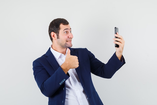 Young male showing thumb up on video chat in shirt