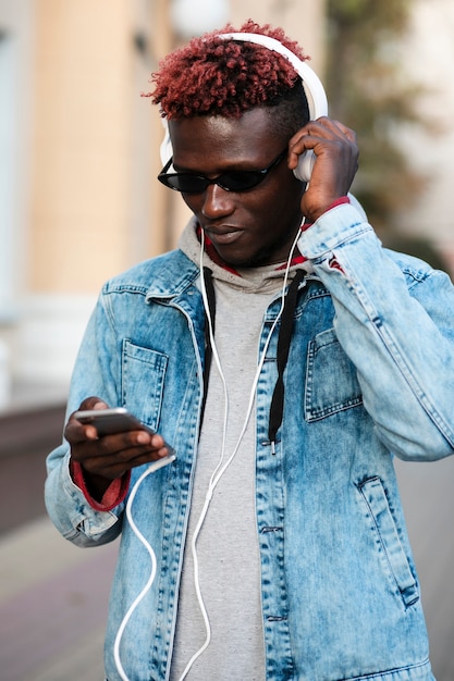 Young male on street listening music
