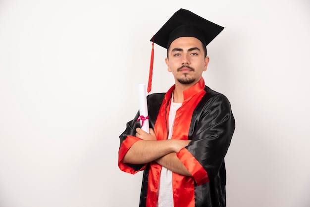 Foto gratuita giovane studente maschio con diploma in posa su bianco.