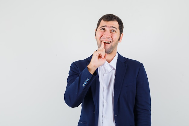 Young male suffering from toothache in shirt, jacket and looking uncomfortable