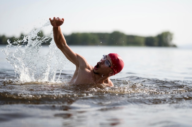 Young male swimming in lake