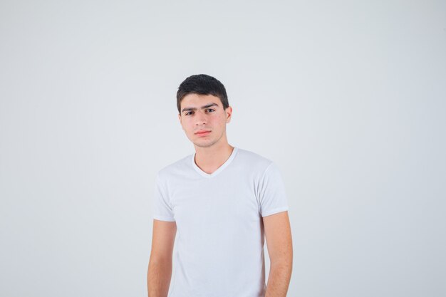 Young male in t-shirt looking at camera and looking confident , front view.