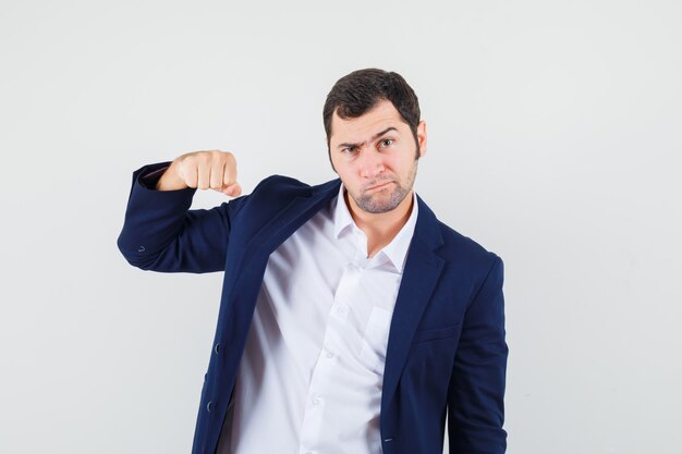 Young male threatening with fist in shirt