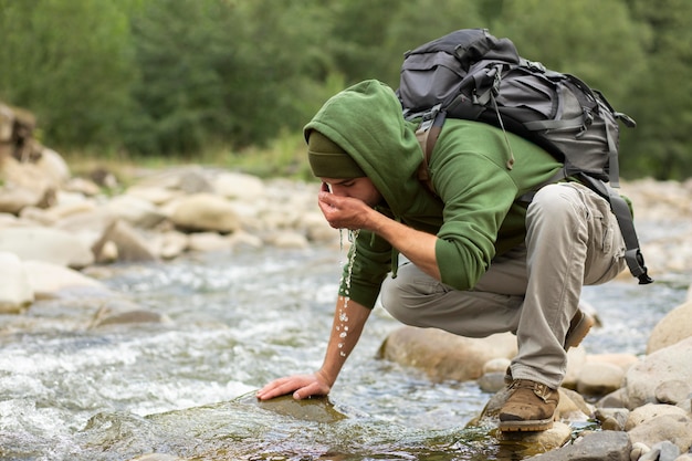 Foto gratuita giovane viaggiatore maschio che si gode un ambiente rurale