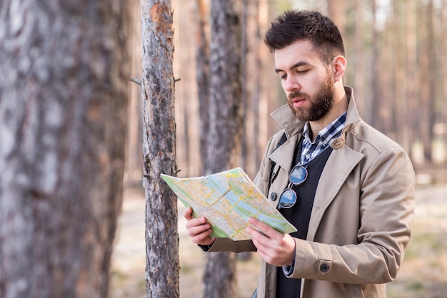 Young male traveler searching for the location in map