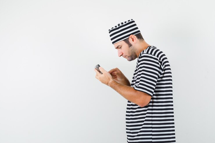 Free Photo young male using calculator in t-shirt, hat and looking busy .