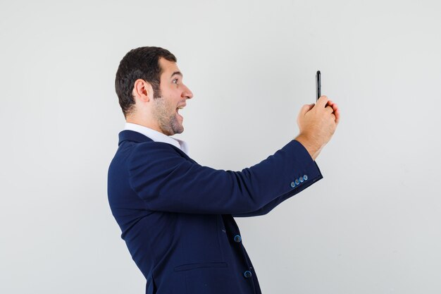 Young male using mobile phone in shirt