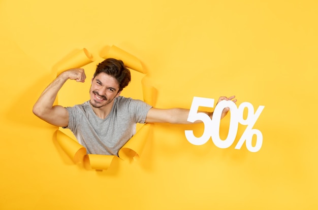 High-Quality Free Stock Photo: Young Male with Inscription Sign on Torn Yellow Background Sale Indoor Guy