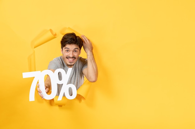 Free photo young male with inscription sign on torn yellow surface