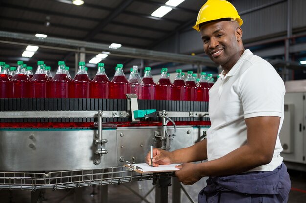 Young male worker noting in factory