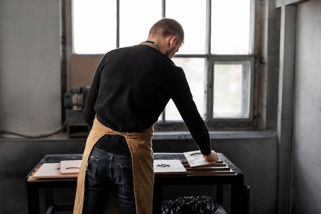 Free photo young male working in a wood engraving workshop