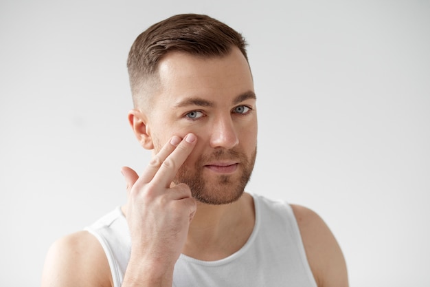 Young man applying his anti aging treatment