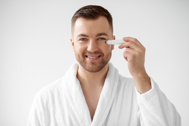 Young man applying his anti aging treatment