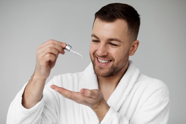 Young man applying his anti aging treatment