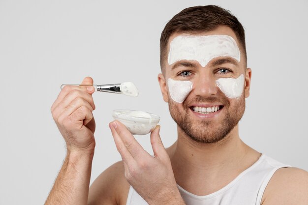 Young man applying his anti aging treatment