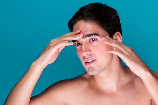 Young man applying skin care