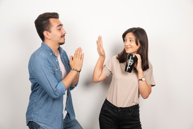 Young man asking a cup of coffee from young woman.