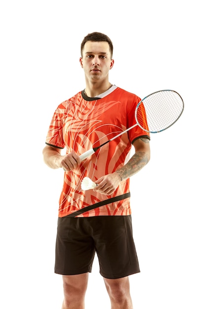 Free photo young man badminton player standing over white studio wall