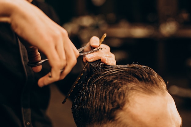 Free photo young man at barbershop trimming hair