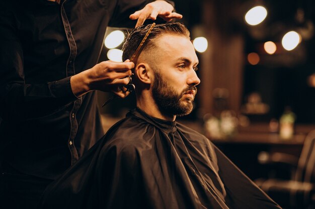 Young man at barbershop trimming hair