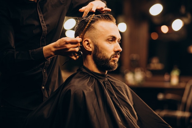 Young man at barbershop trimming hair