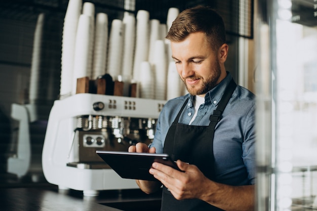 Free photo young man barista at a coffee shop