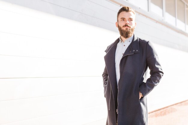 Free photo young man in black jacket standing at outdoors