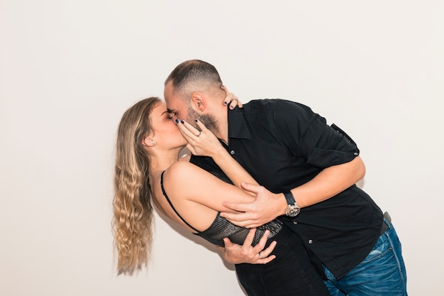 Young man in black kissing woman 