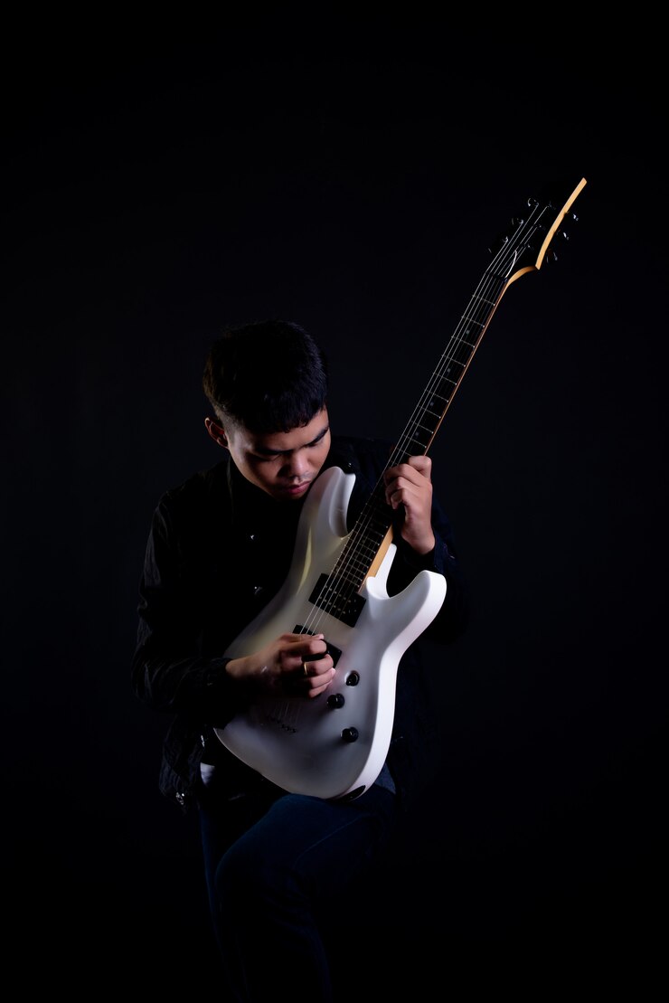 Free Photo young man in black leather jacket with electric guitar