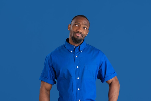 Young man on blue studio wall