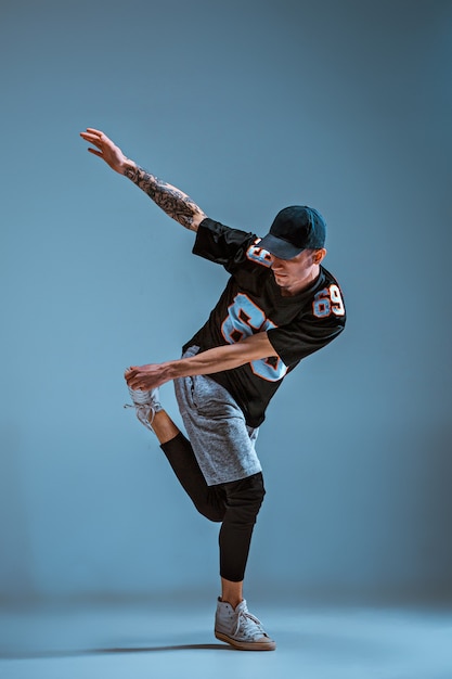 Young man break dancing on wall background.