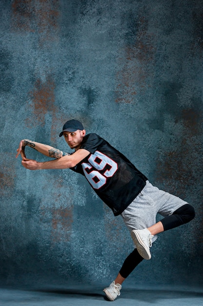 Free photo young man break dancing on wall wall.