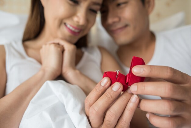 Young man bringing ring box for his girlfriend at his home