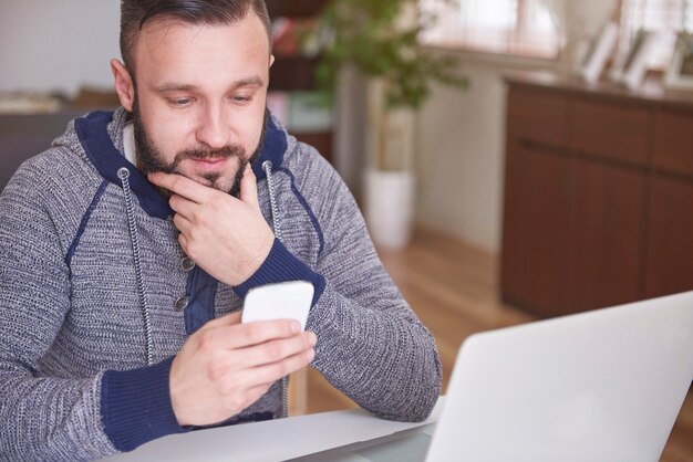 Young man browsing contacts in his telephone