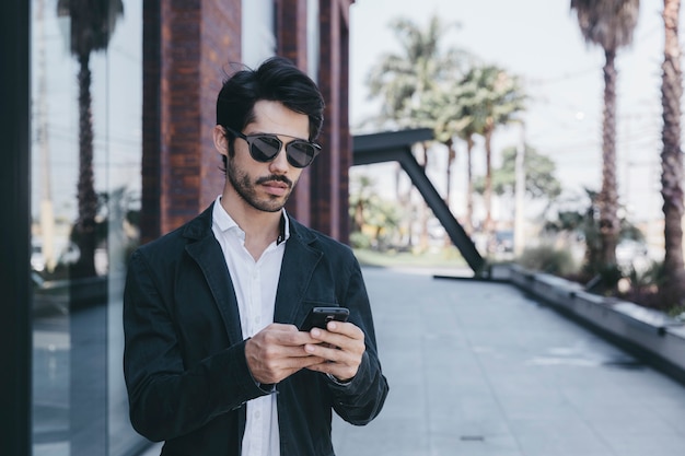 Free photo young man browsing smartphone