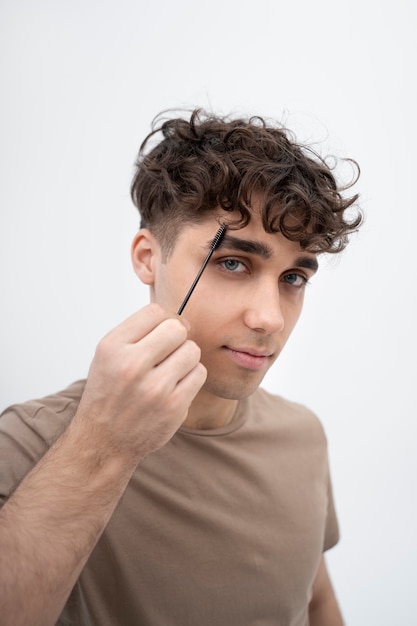 Young man brushing his eyebrow