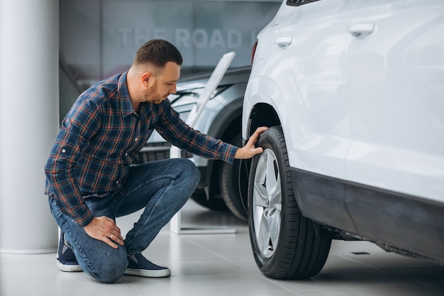 Young man buying a car in a car showroom