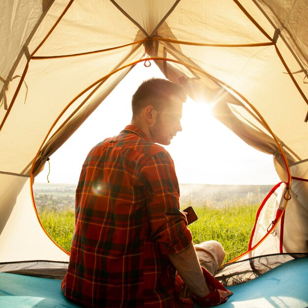 Young man in camping tent