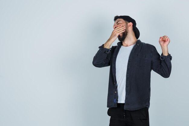 Young man in cap looking sleepy