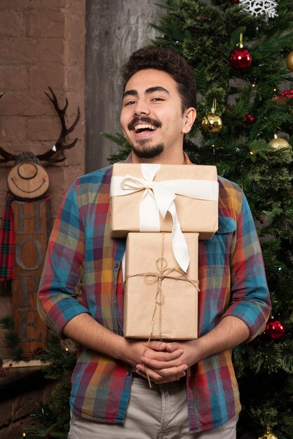 Young man carries a lot of presents.