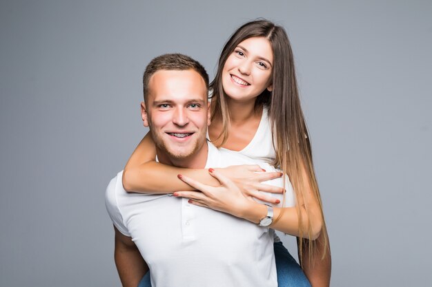 Young man carrying his young girlfriend on his back in studio