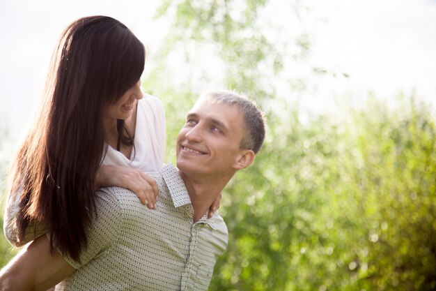 Young man carrying piggyback his girlfriend