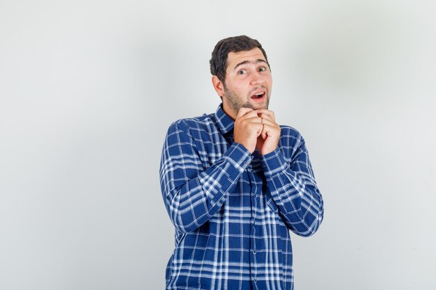 young man in checked shirt asking for something in cute pose