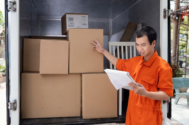 Free photo young man checking details of parcels before delivery