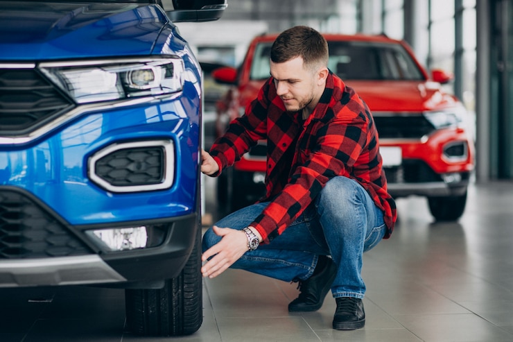 Бесплатный Фотография молодой человек выбирая автомобиль в автосалоне